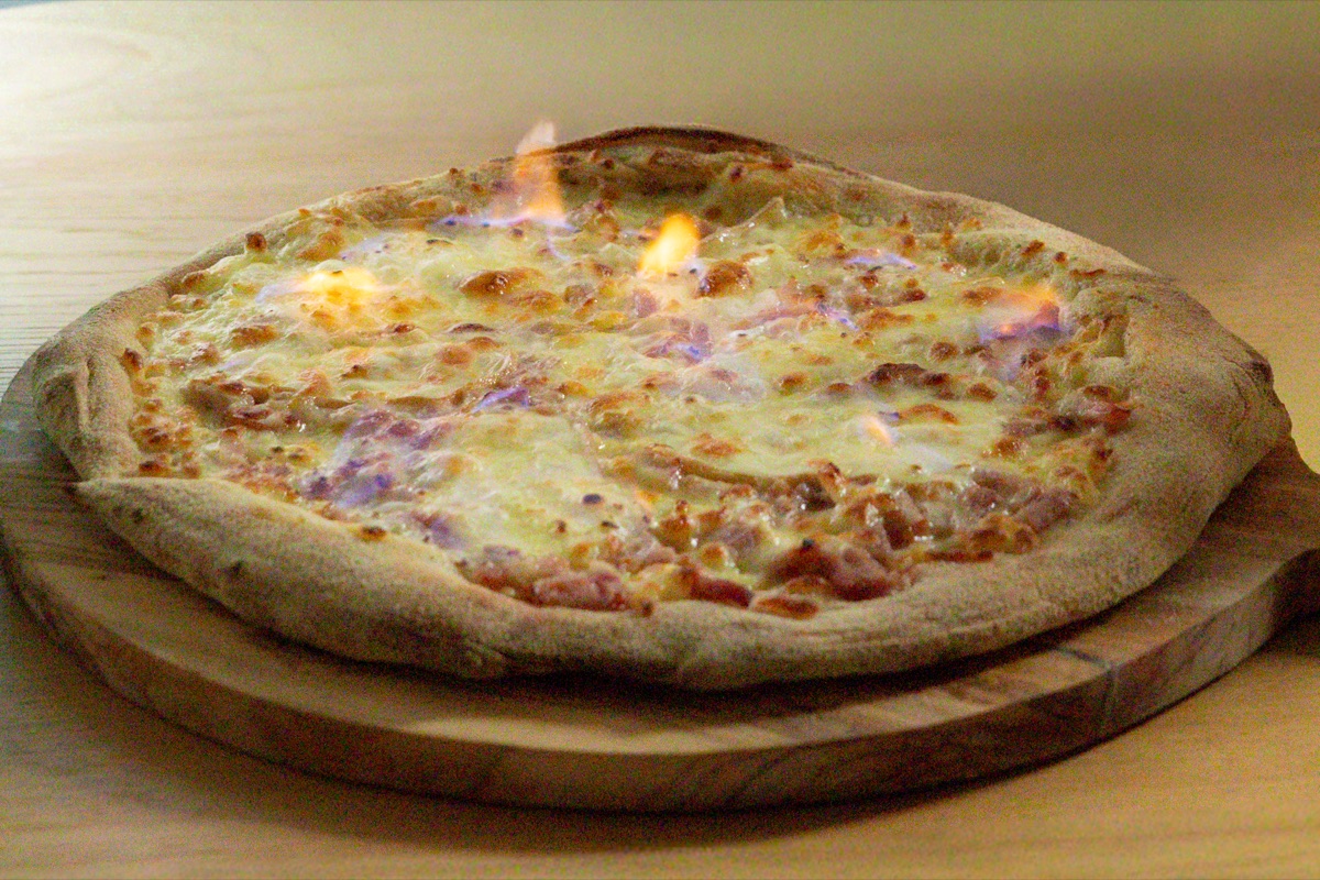 Gros plan pizza en flammes - croûte dorée et fromage fondu